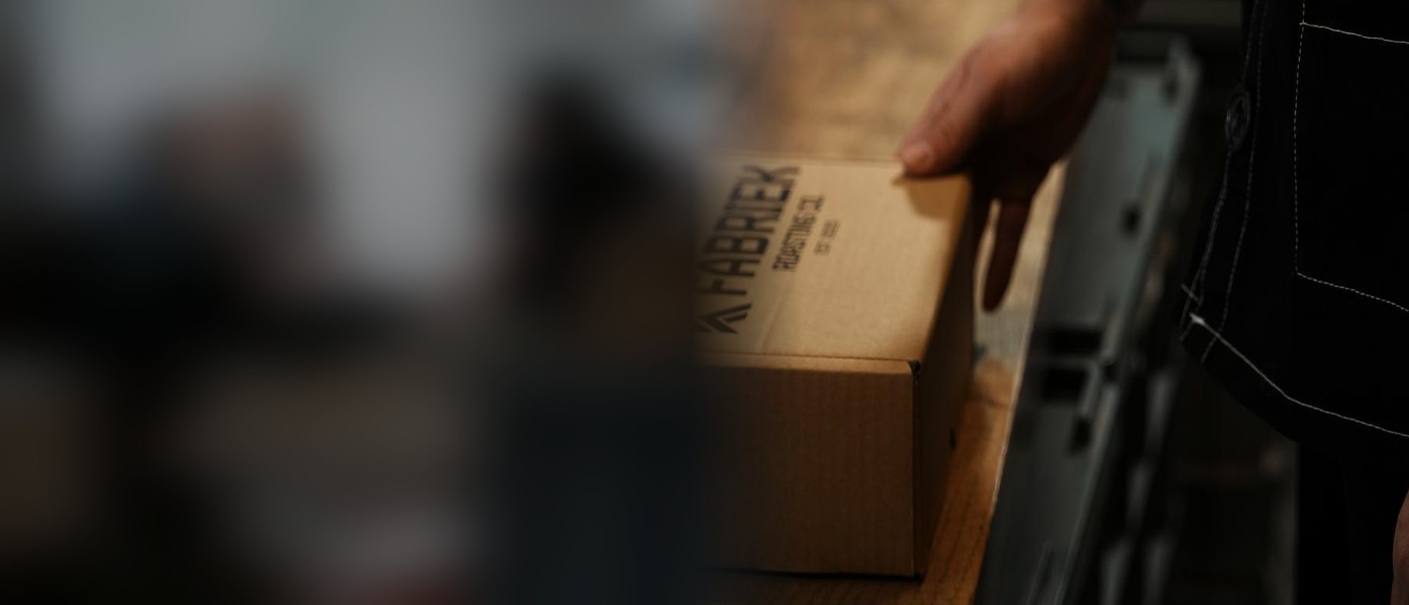 A hand on a FABRIEK Roasting Co. box